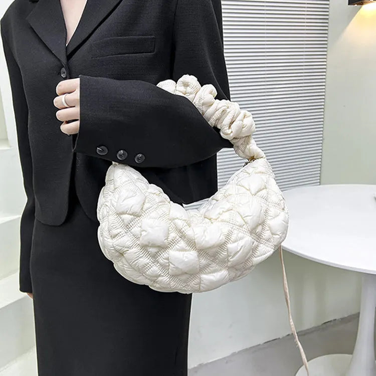 Women's light grey nylon underarm messenger bag with adjustable long strap, shown worn crossbody.