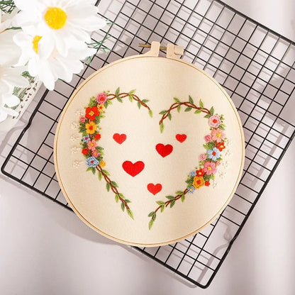 DIY Valentine's heart embroidery kit with cotton cloth and 20cm bamboo ring on a table.