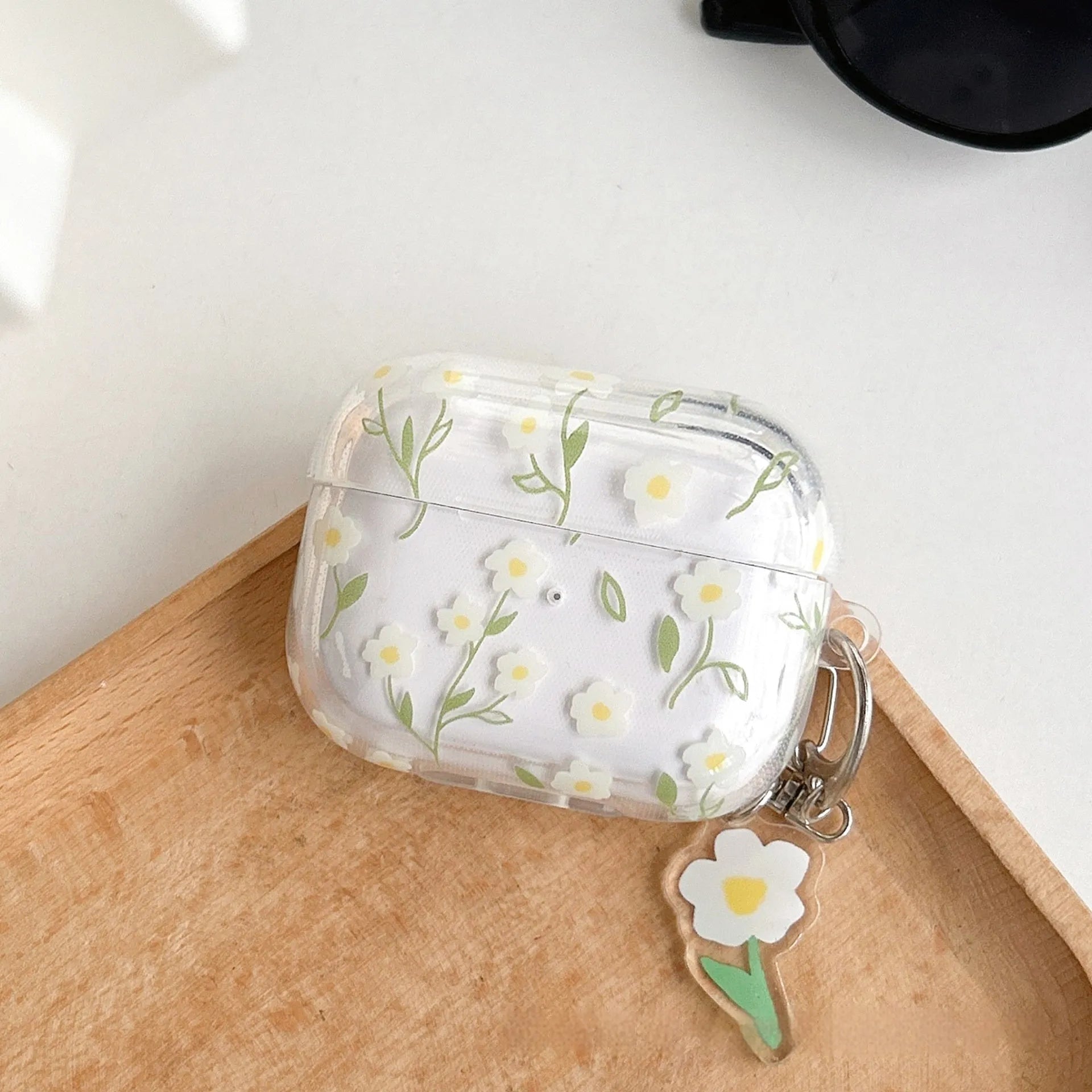 Clear white floral TPU protective cover on an Apple AirPods Pro charging case.