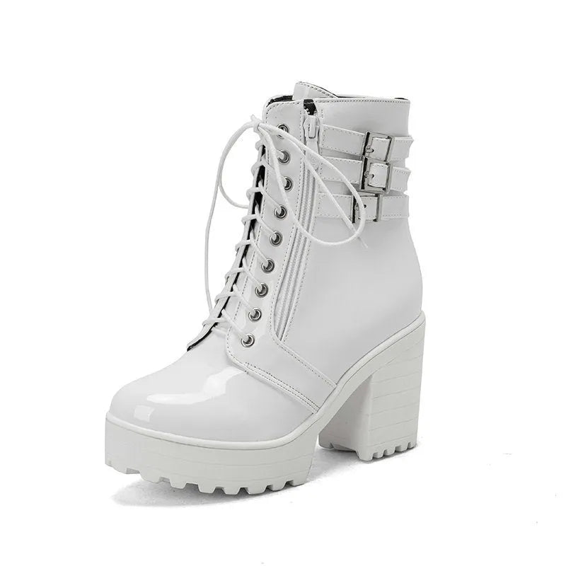 Women's black chunky heel ankle boots with round toe and front lace-up on a wooden floor.