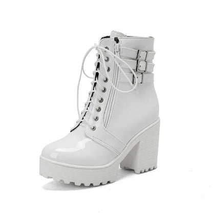 Women's black chunky heel ankle boots with round toe and front lace-up on a wooden floor.
