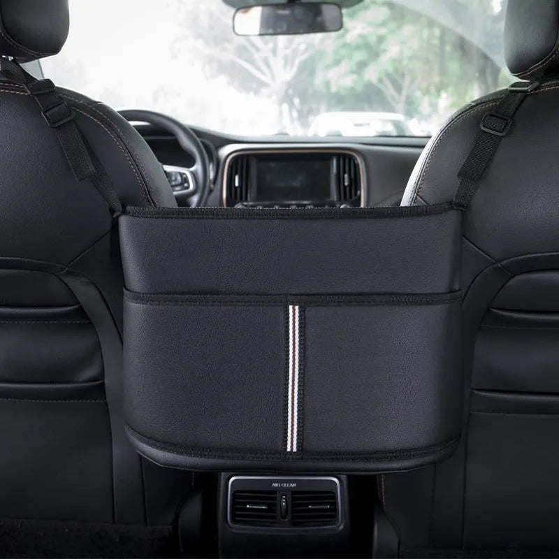 Black leather car seat gap storage bag hanging from armrest with tissue box, showing textured grain detail.