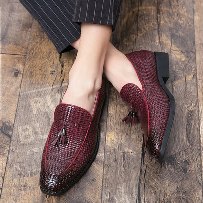 Men's black pointed toe slip on shoes with a tassel detail on the upper.