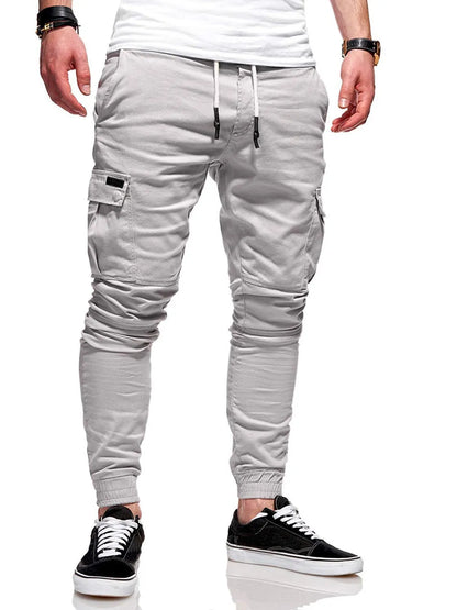 Men's light blue polyester loose-fit straight-leg trousers with dimensional patch pockets and elastic waistband laid flat.