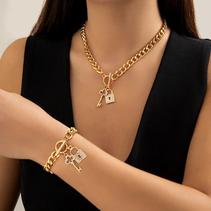 Elegant chain necklace and bracelet set with shiny lock and key pendant, fashionable ladies accessories