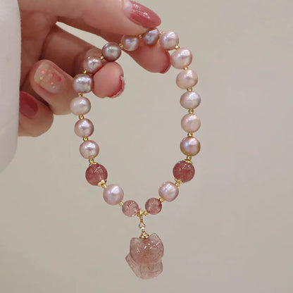 Women's light pink freshwater pearl bracelet with strawberry quartz stones and fox charm