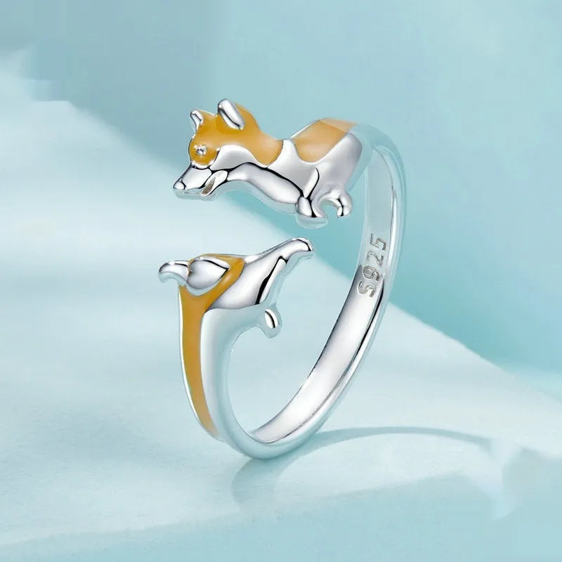 Close-up of an adjustable silver-toned ring with a detailed cartoon corgi dog design.