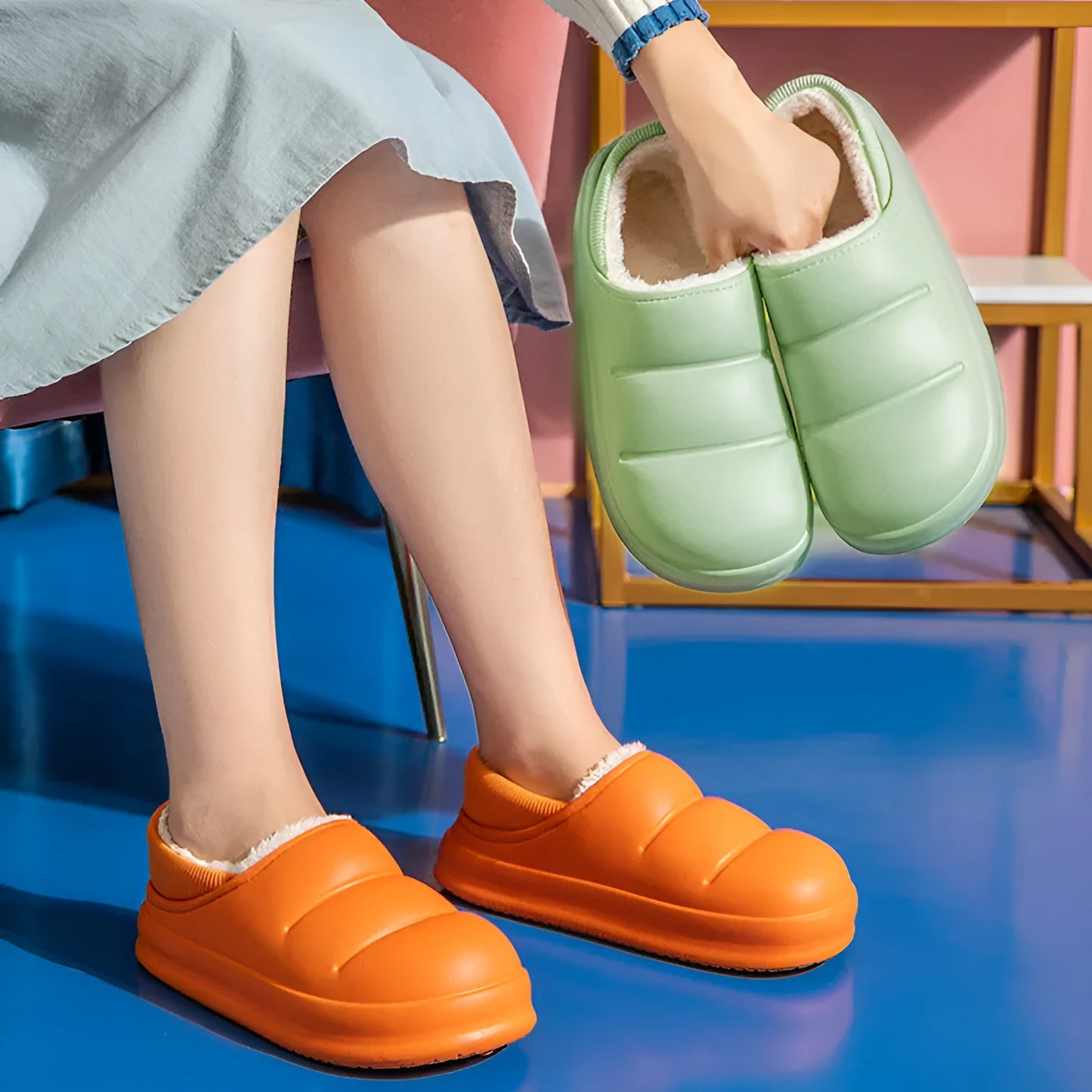 Pair of yellow waterproof EVA slippers with plush lining and a textured non-slip sole on a wooden floor.