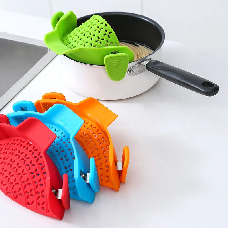 Silicone and stainless steel pot side drain stopper kitchen gadget in assorted colours.