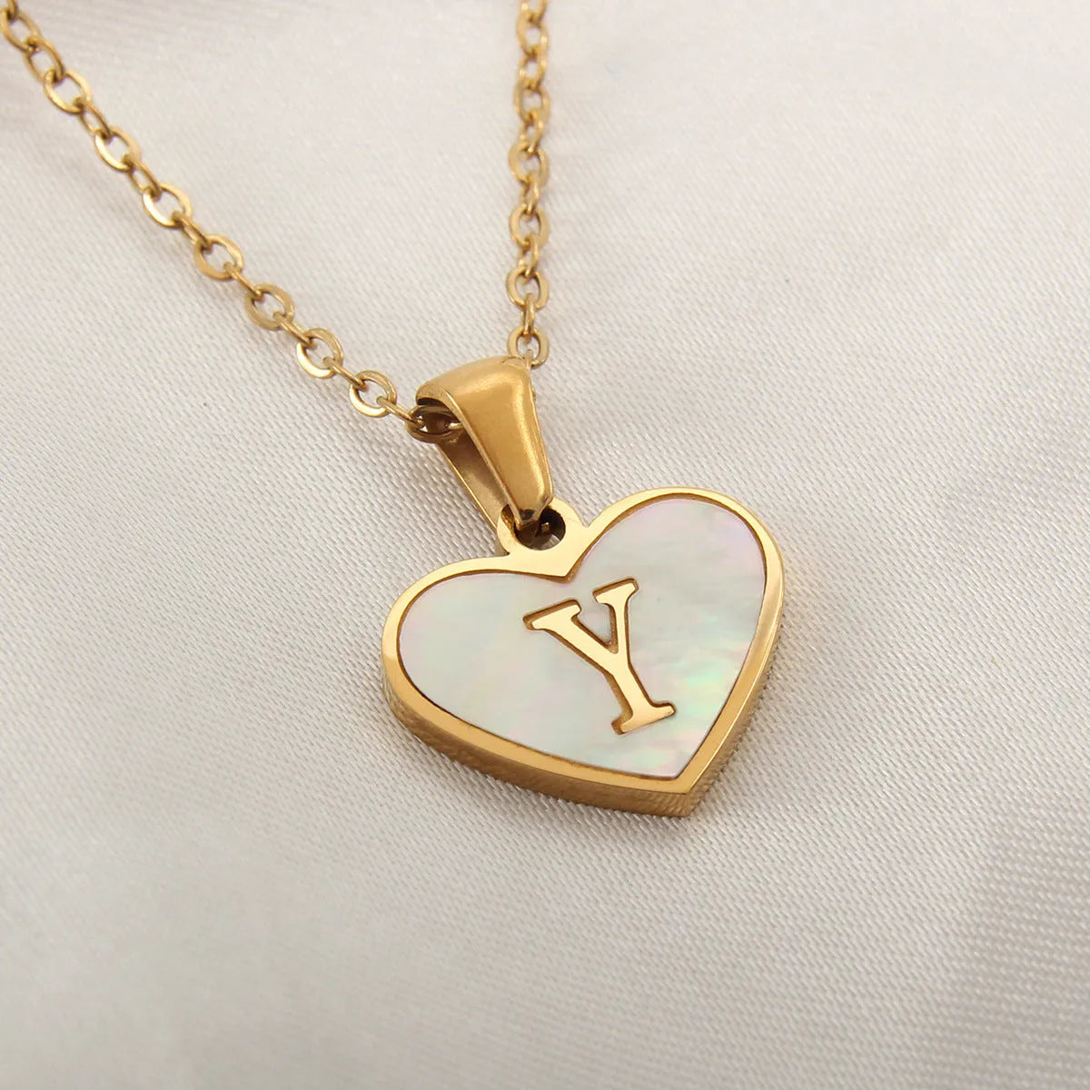 Gold-plated heart necklace with white shell pendant showing letter personalisation option