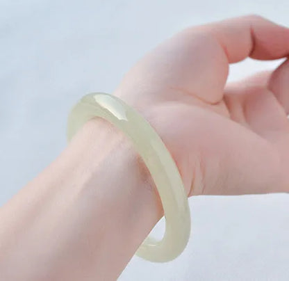 Ice silk jade round bar bracelet shown on a wrist, highlighting its smooth cylindrical shape and natural stone material.