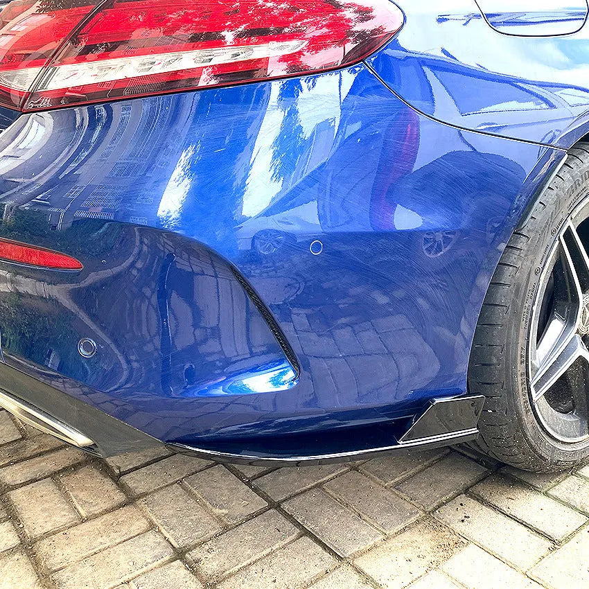Car rear corner protectors in PP plastic, shown in piano black and carbon fibre pattern finishes