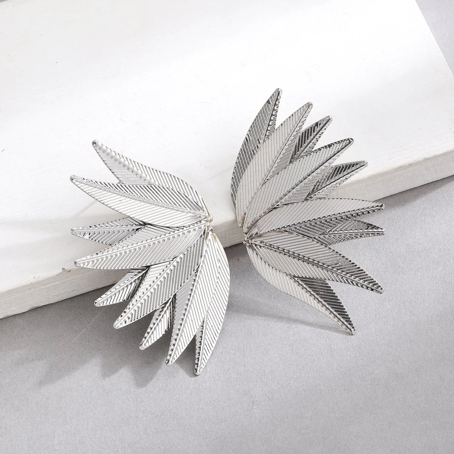 Gold and white alloy leaf-shaped patch earrings with botanical design