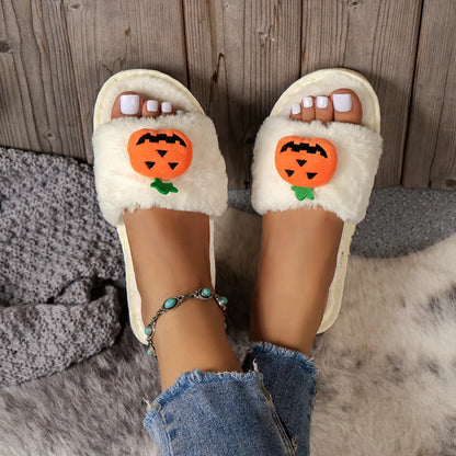 Yellow pumpkin plush open-toe slippers with synthetic fur and textured PVC sole on wooden floor.