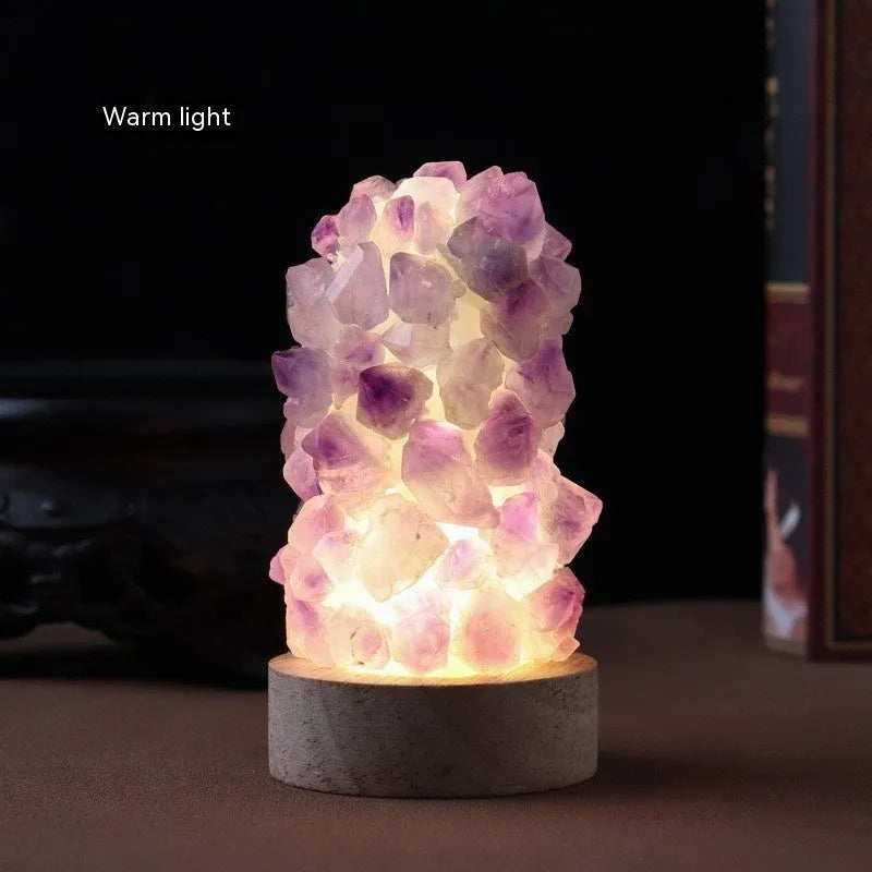 Mini USB night light glowing inside a natural amethyst crystal vug geode on a dark surface.
