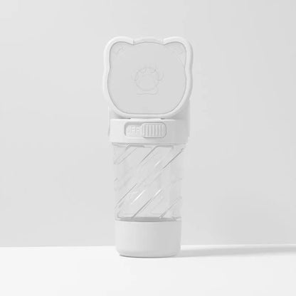 Green 3-in-1 pet water bottle with strap, showing water dispenser, food container, and waste bag dispenser for outdoor use