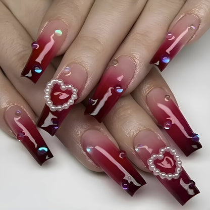 Set of long false nail tips with wine red gradient colour, plaid pattern, and a pearl heart design.