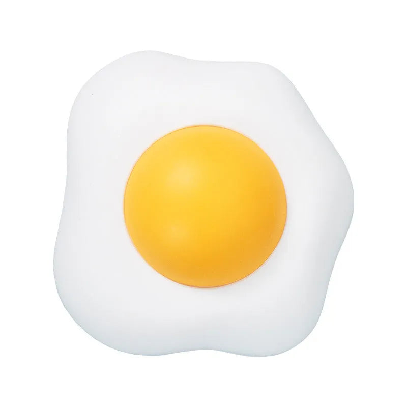 Fried egg shaped plush cat toy stuck to a window with a cat paw batting the 360-degree rotating ball.