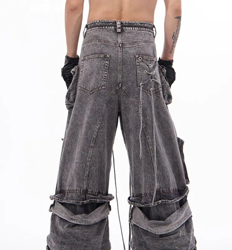 Grey distressed denim overalls jumpsuit with rope stitching on a hanger.