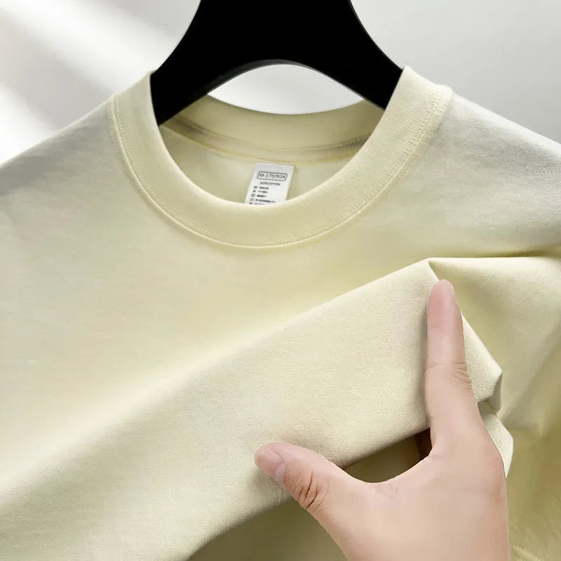 Men's thin cotton drop shoulder t-shirt on a hanger, shown in a light colour.
