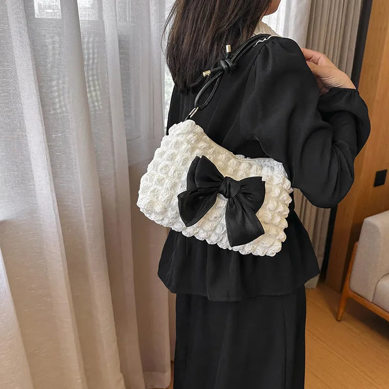 Women's black canvas single shoulder handbag with a sandwich pocket and horizontal square shape.