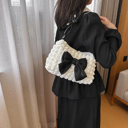 Women's black canvas single shoulder handbag with a sandwich pocket and horizontal square shape.