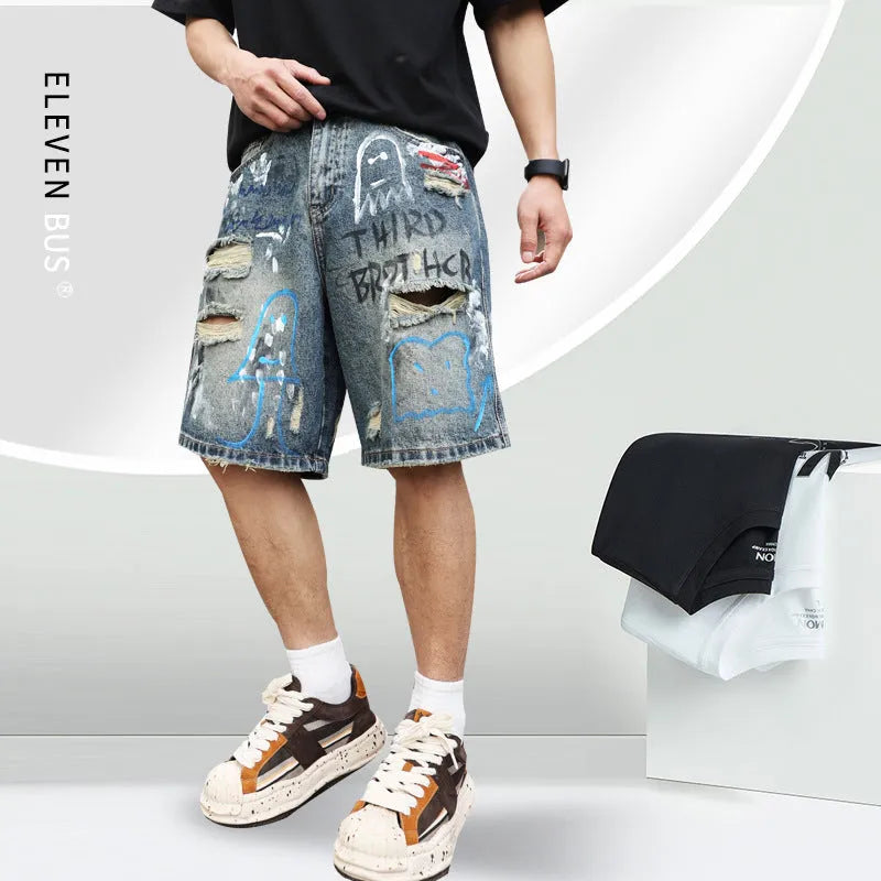 Blue men's jeans shorts with ripped distressed detailing and graffiti design, straight leg cut with zipper fly