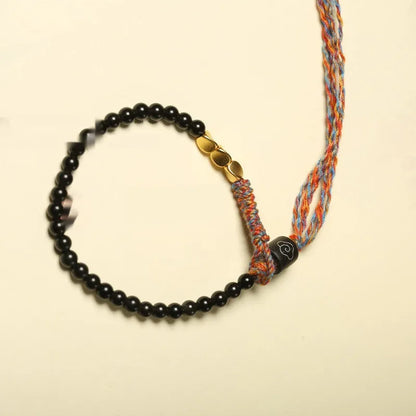 Close-up of a hand-woven obsidian bracelet with a 4mm wide strap on a wrist.