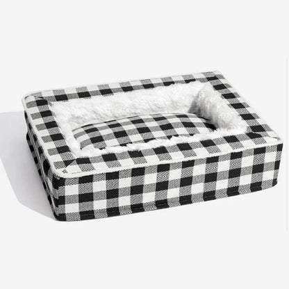 Classic red plaid dog bed cushion with a removable cover, shown in a large size next to a dog crate.