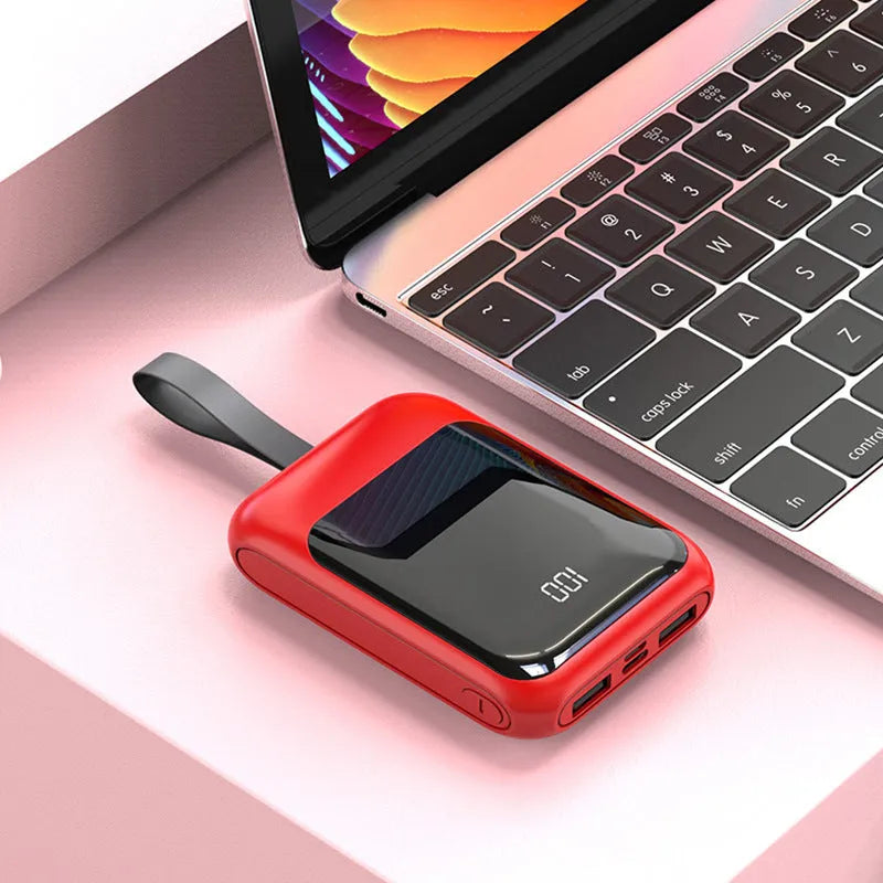 White portable power bank with 20000mAh capacity and multiple USB output ports on a table.