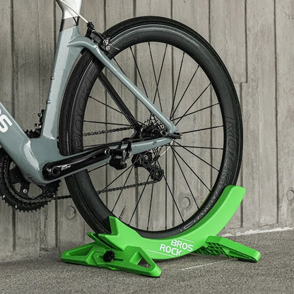 A black wall-mounted ABS plastic bracket holding a mountain bike vertically for storage.