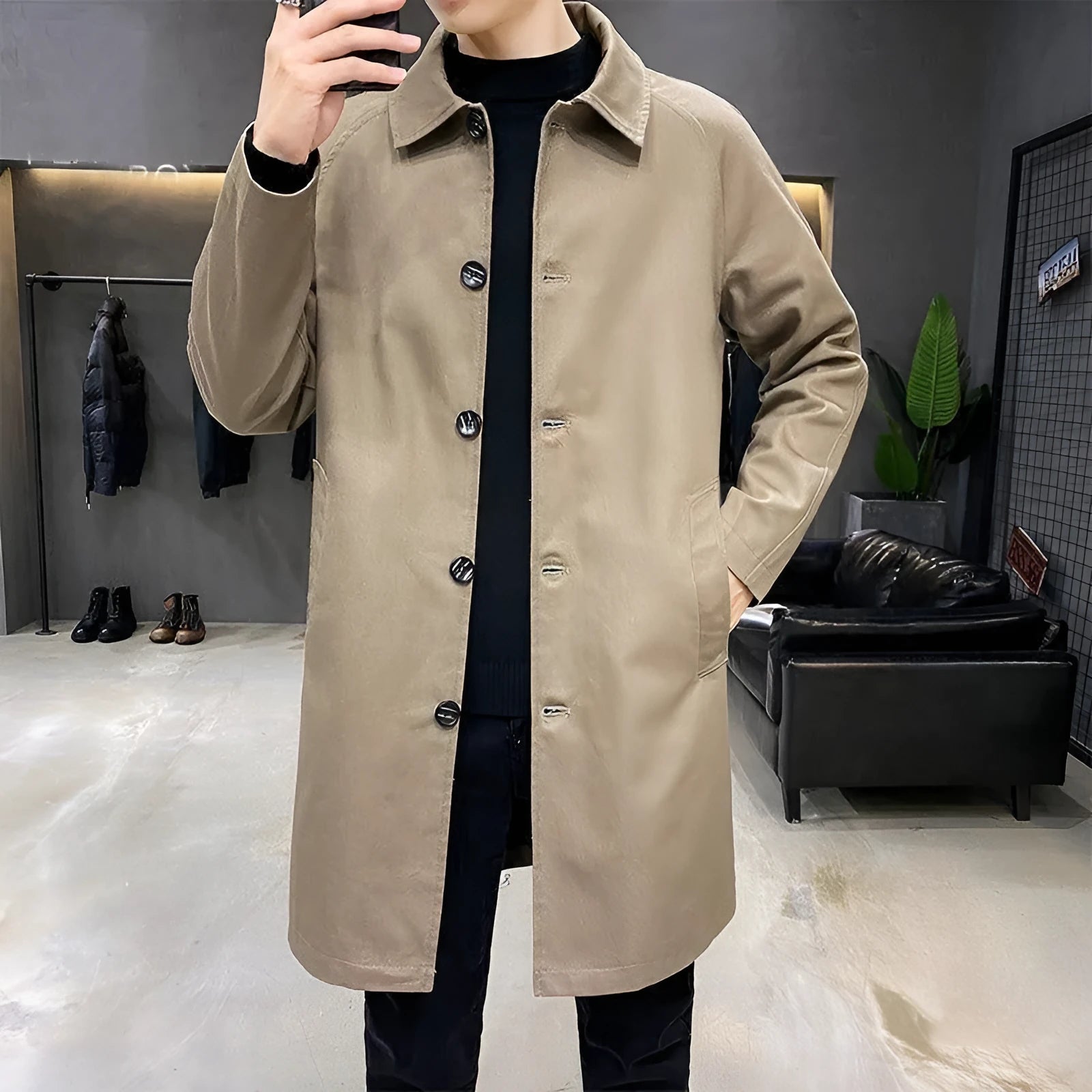 Man wearing a khaki coloured loose fit mid-length trench coat made from rabbit fur fabric.