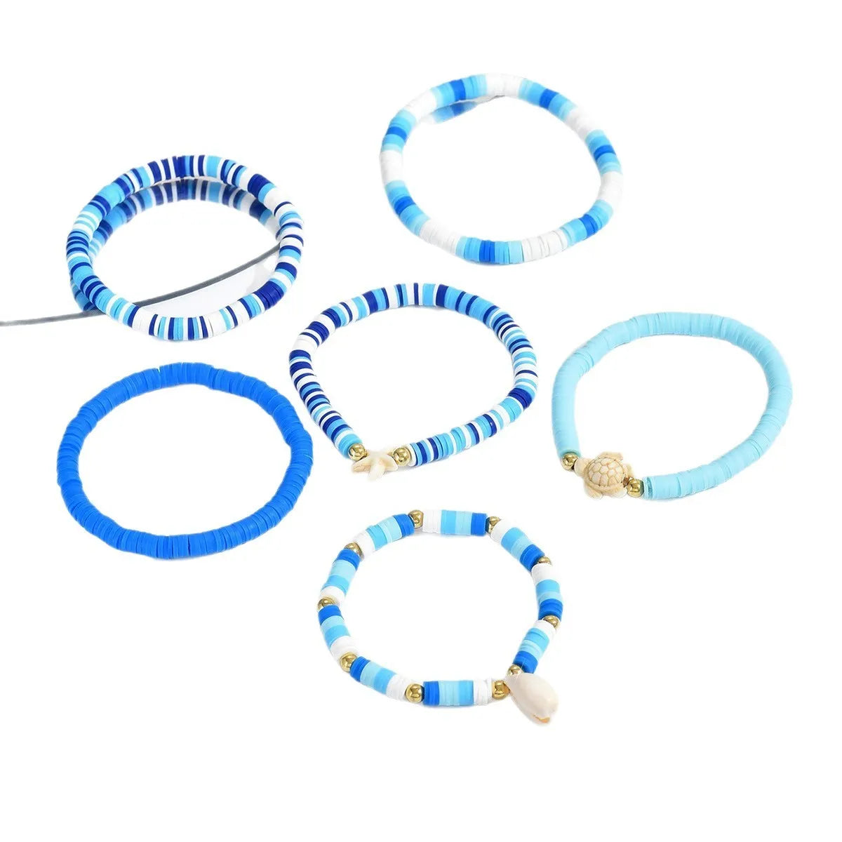 Six handmade Bohemian Blue polymer clay bracelets with geometric shell designs arranged together