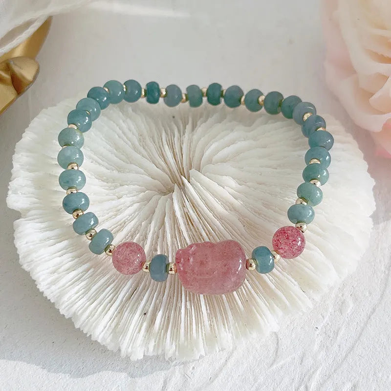 Simple blue jade bracelet with gourd charm, peace buckle, and adjustable cord on woman's wrist