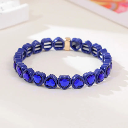 Colourful enamel heart shape on a silver-toned alloy stretch bracelet.