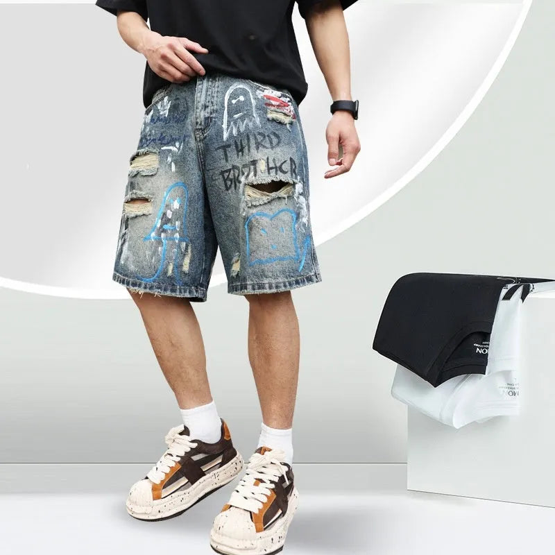 Blue men's jeans shorts with ripped distressed detailing and graffiti design, straight leg cut with zipper fly