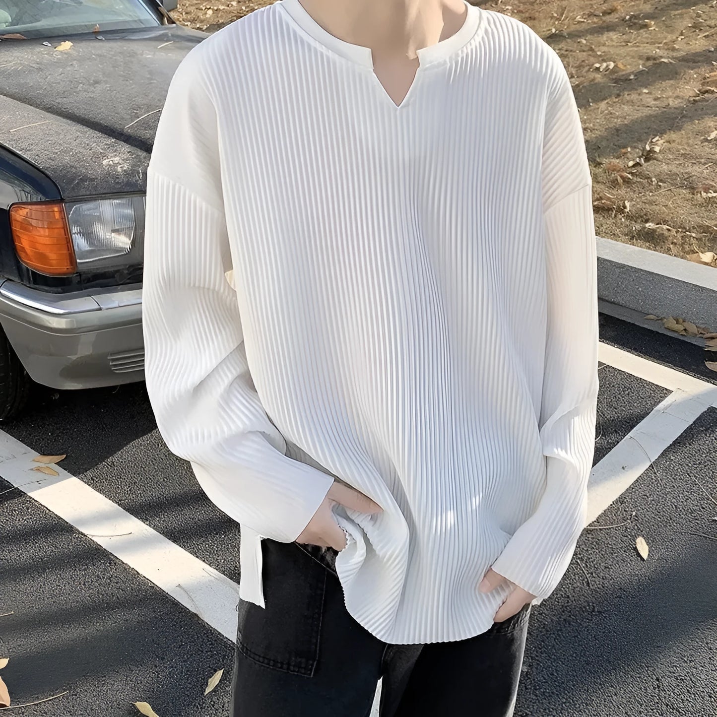 A woman wearing a black and white striped, loose-fit, long-sleeve pullover jumper.
