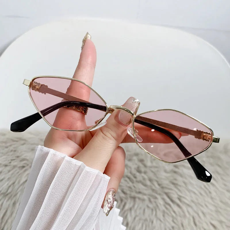 Gold metal frame rhombus-shaped cat eye sunglasses on a neutral background.