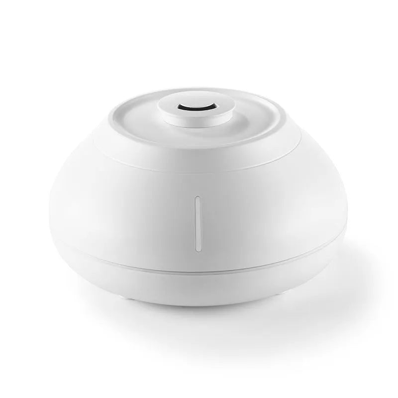 White rounded desktop aroma diffuser with colourful flame-like light and mist plume on a wooden table.