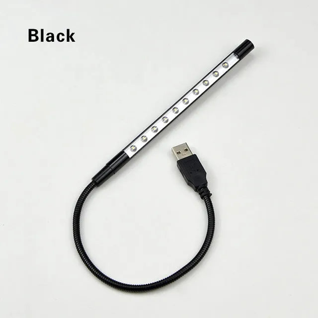 Spiral shaped silver aluminium USB LED desk lamp bent on a wooden desk.