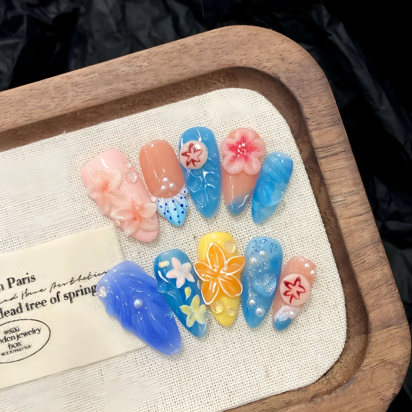 Three-dimensional plastic wearable armour set with carved jellyfish decorations in almond nail colour.