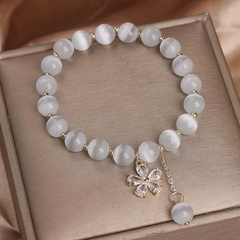 Women's white cat's eye crystal bracelet with flower tassels and a morganite safety buckle pendant.