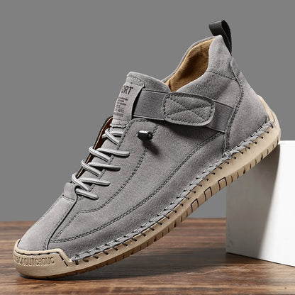 Men's black mid-top Martin boots with elastic band and sewn sole on a plain background.