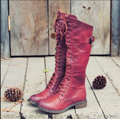 Women's black knight ankle boots with cross straps and buckles over lace-up front.