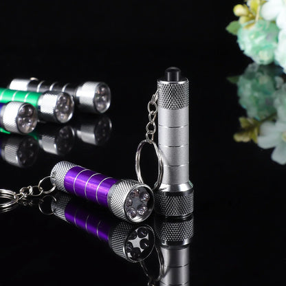 Compact aluminium LED keychain torch in four colours: white, black, red, and blue.