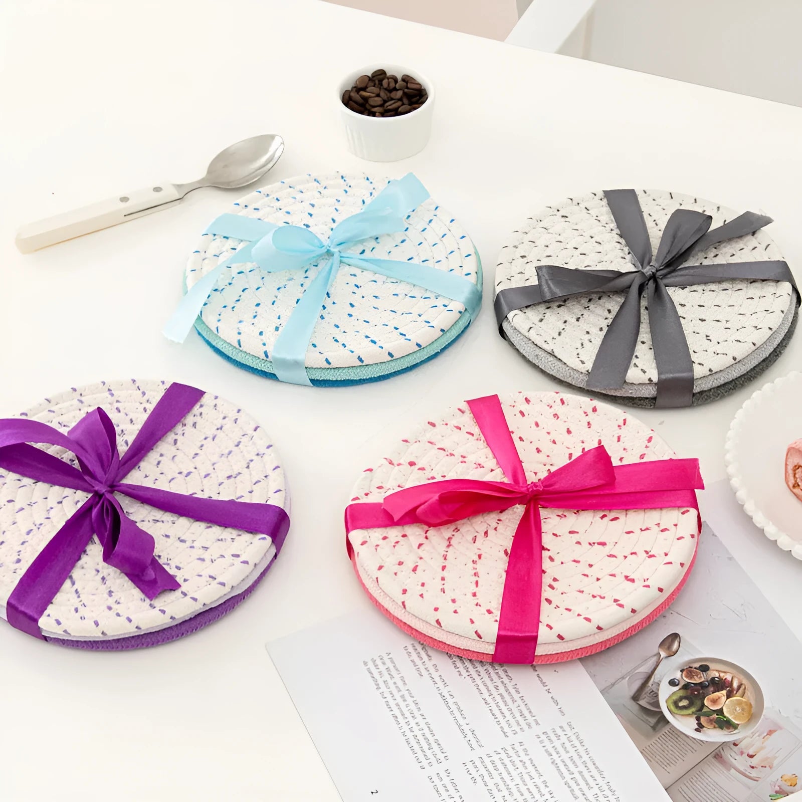 Three round grey cotton cord coaster placemats on a wooden table, each 18cm in diameter.