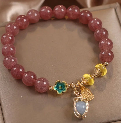 Red beaded bracelet with strawberry quartz gems, alloy clasp, and rhinestone details.