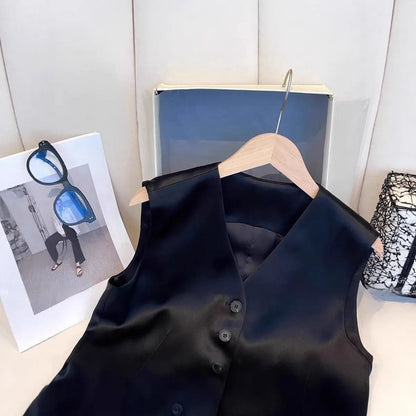 Black satin sleeveless vest on a hanger, showing loose fit and splicing detail.