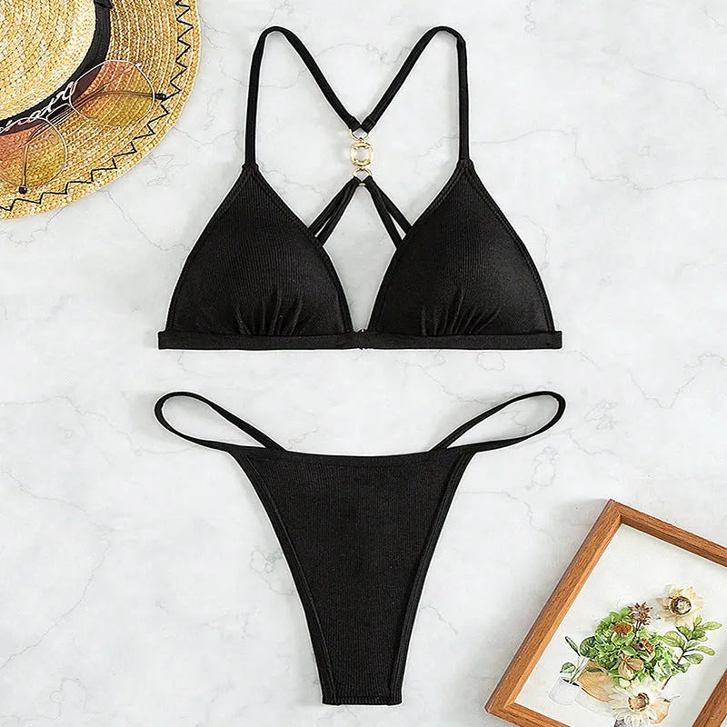 Black women's bikini set with hollow backless triangle top and matching briefs on a neutral background.