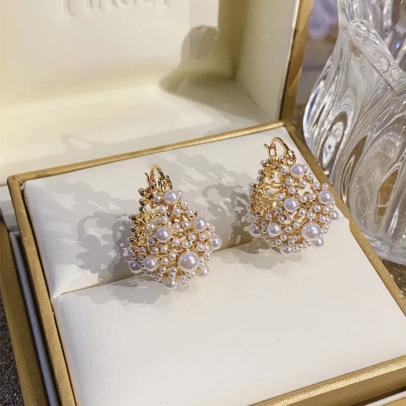 Gold-coloured women's floral basket earrings made from copper with small bead and pearl inlay detail.